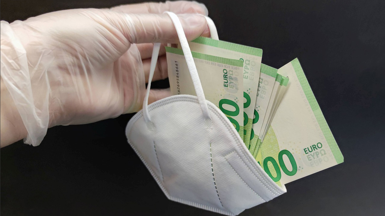 100-Euro-Scheine in einer FFP2-Maske